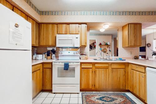 a kitchen with wooden cabinets and white appliances at Gold Dust F3 in Angel Fire