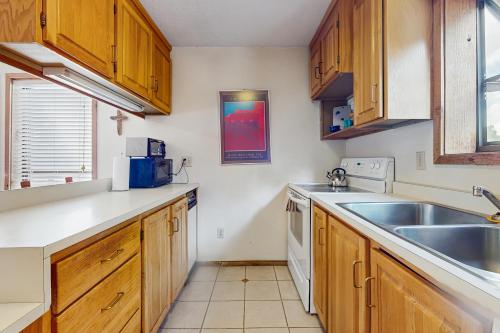 a kitchen with wooden cabinets and a sink at Lift A4 Condo in Angel Fire