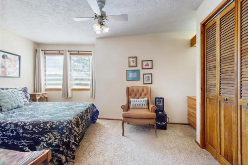 a bedroom with a bed and a chair and a ceiling fan at Lift A4 Condo in Angel Fire