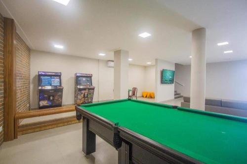 a room with a pool table and arcade machines at Ilha Porchat Hotel in São Vicente