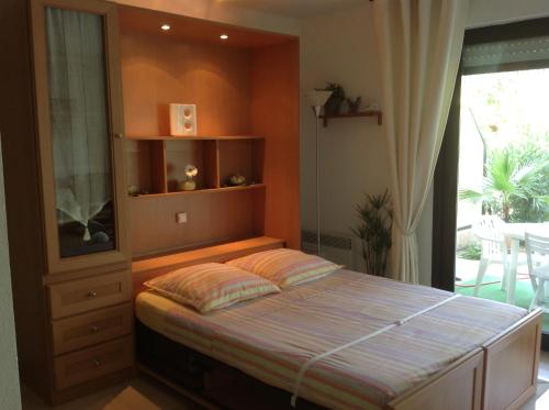 une chambre avec un lit dans une pièce avec une fenêtre dans l'établissement Studio en rez de jardin dans résidence calme avec piscine, à Juan-les-Pins