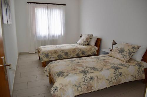 a bedroom with two beds and a window at Appartamento sole in Isone