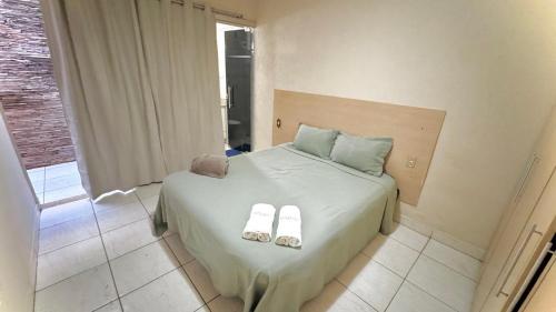 a bedroom with a bed with slippers on it at Casas de Temporadas - Hotel Recanto do Sossego in Uberlândia
