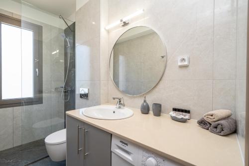 a bathroom with a sink and a toilet and a mirror at Maera Apartments in Sami