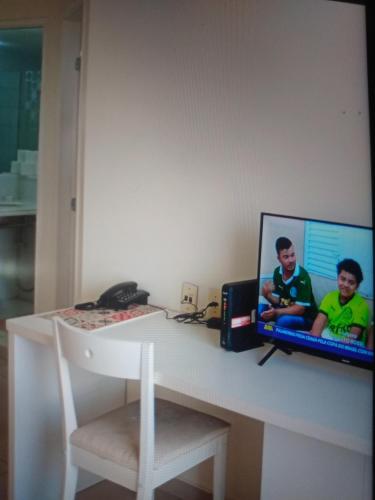 een bureau met een computer met twee kinderen erop bij Hotel glamuroso in Guarulhos