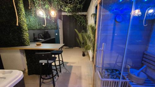 a kitchen with a shower and a table and stools at Botanica - Private Spa in Saint-Quentin