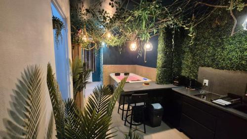 une salle de bain avec des plantes sur les murs et un lavabo dans l'établissement Botanica - Private Spa, à Saint-Quentin