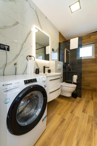 a washer and dryer in a bathroom with a toilet at Luxury Apartment Luce in Novigrad Dalmatia