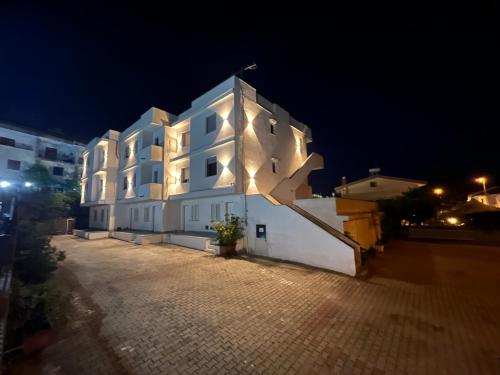 un grande edificio bianco con luci accese di notte di Casa Vacanze Tortora a Tortora