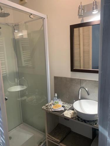 une salle de bain avec une douche en verre et un lavabo dans l'établissement Le Grain de Sable, à Berck-sur-Mer