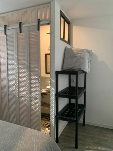 Cette chambre comprend un lit et une étagère à côté d'une porte. dans l'établissement Le Grain de Sable, à Berck-sur-Mer