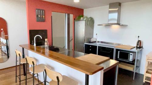 a kitchen with a counter with chairs and a sink at The Cliffs - OceanLight 
