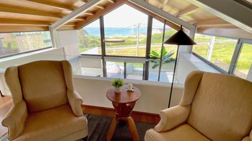 two chairs and a table in a room with a window at The Cliffs - OceanLight 