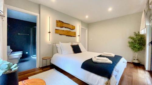 a bedroom with a large white bed and a bathroom at The Cliffs - OceanLight 
