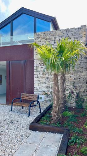 a bench in front of a building with a palm tree at The Cliffs - OceanLight 