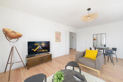 un salon avec un canapé et une télévision dans l'établissement Amiral, Cocooning et Familial, à Rouen