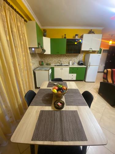 a kitchen with a table with a bowl of fruit on it at The Citrus Tree Apartments in Vlorë