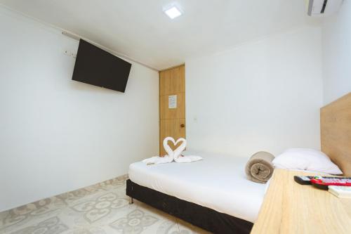 a hotel room with a bed and a tv at Hotel Colores Boutique in Medellín