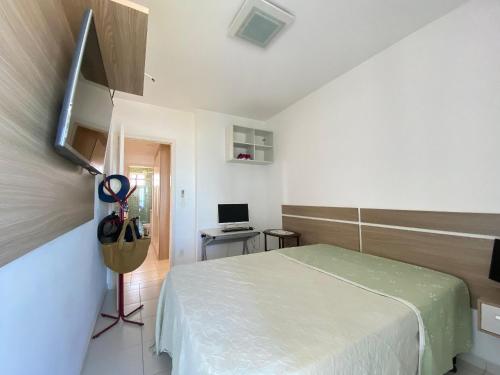 a bedroom with a bed and a desk with a computer at Apto Alto Padrão Frente Mar no melhor condomínio in Samaritá