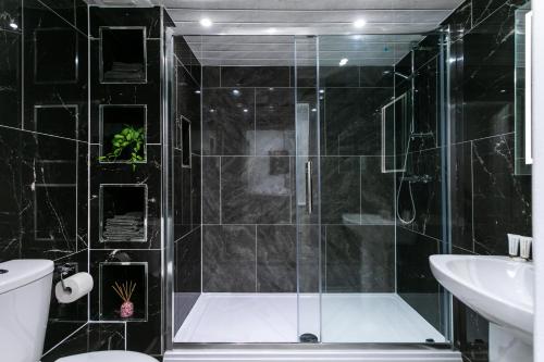 a bathroom with a shower and a toilet and a sink at Luxury Retreat in the Heart of Leicester City Centre! in Leicester