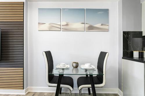 a dining room with a glass table and black chairs at Luxury Retreat in the Heart of Leicester City Centre! in Leicester