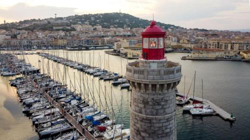 un phare avec une tour d'horloge dans une marina dans l'établissement Rosa Verde, à Sète