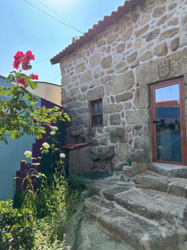 an old stone house with a window and stairs at Casa do Arte - Peaceful Retreat with a Pool near Guimarães in São Torcato