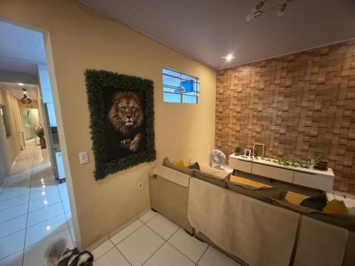 a living room with a lion picture on the wall at Quarto em AP compartilhado Ponta da areia in São Luís