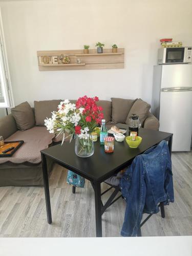 un salon avec une table avec des fleurs dessus dans l'établissement Entre montagne et mer, à La Valette-du-Var