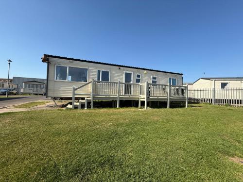 a mobile home with a porch and a yard at Pet Friendly Location Close To Beach in Ingoldmells