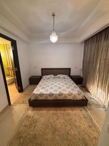 a bedroom with a bed and a chandelier at Lac 2 البحيرة in Tunis