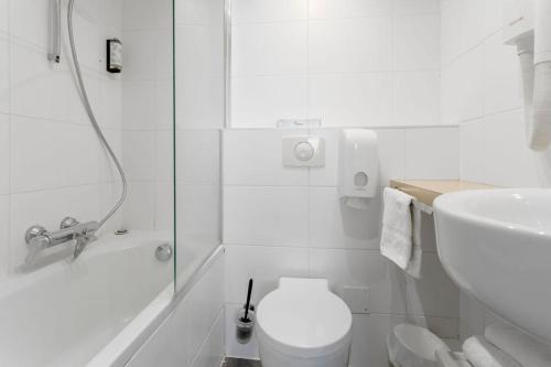 a white bathroom with a toilet and a shower at Kyriad Deauville - St Arnoult in Deauville