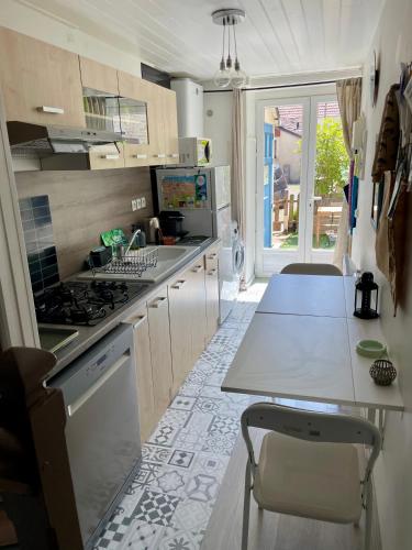 une cuisine avec une cuisinière et un comptoir dans l'établissement La Victoire, à Saint-Aubin-sur-Mer