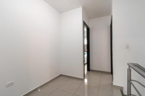 an empty hallway with white walls and a door at Casa Amplia, Piscina privada, Vía Samborondón, parrilla in Amalia