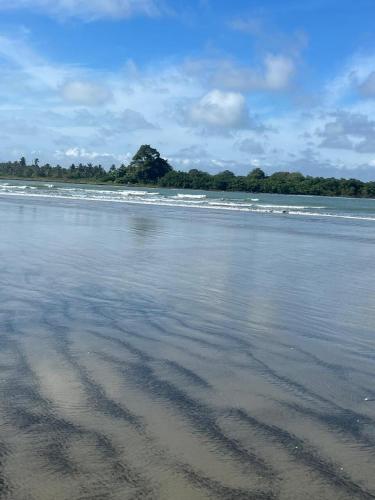 a sandy beach with waves in the water at Casa Amare Bolivar Zapotal Island 14pax 7hab in Muisne