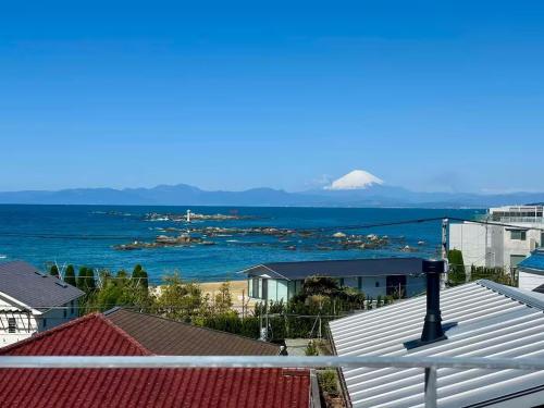 a view of the ocean from the roofs of houses at 葉山 森戸海岸すぐの富士山と海が一望できる新築ヴィラ bbq サウナ in Hayama