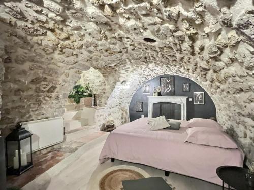a bedroom with a bed in a stone wall at L'epicurisme in Lorgues