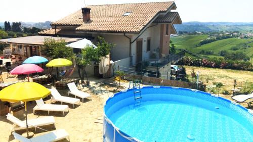 une maison avec piscine, chaises et parasols dans l'établissement Tenuta Ornella, à Miglianico