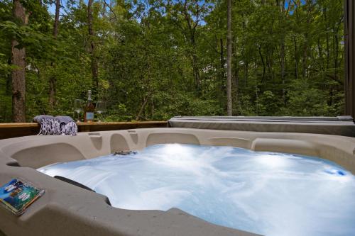 a hot tub with a view of a forest at Couple's Cabin With Outdoor Movies, Firepit and Hot Tub - Rose Peak Loft in Blue Ridge