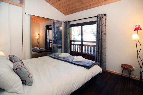a bedroom with a large bed and a balcony at Superbe Appartement Deux Alpes Cosy et chaleureux 6 personnes in Les Deux Alpes