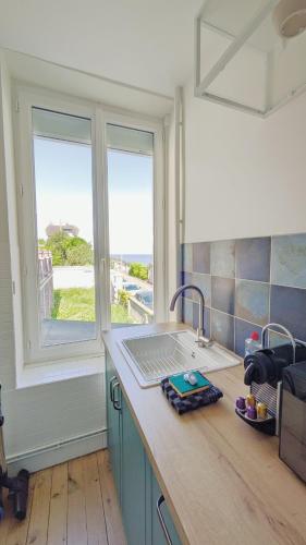 d'une cuisine avec un comptoir, un évier et une fenêtre. dans l'établissement Il Nido 2, F2 hyper centre, parking et wifi, à Villers-sur-Mer