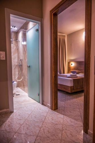 a bathroom with a shower and a bedroom with a bed at Ador El Mar in Leptokarya