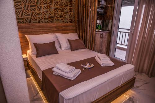 a bed in a room with towels on it at Ador El Mar in Leptokarya
