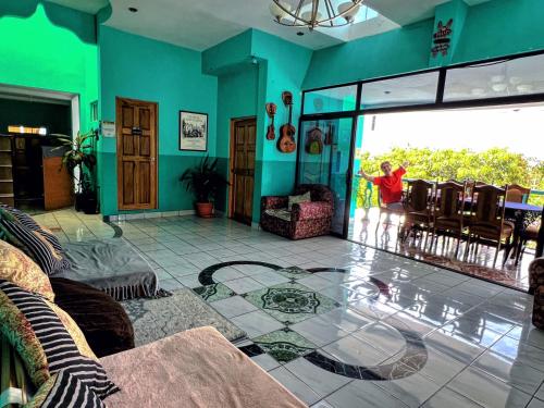 un salon avec un enfant debout devant une porte vitrée dans l'établissement Samay Hostel, à Juayúa