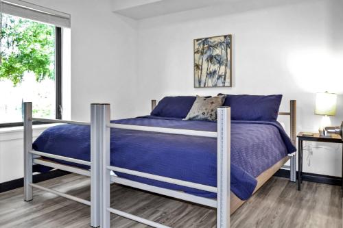 a bedroom with a bed with blue sheets and a window at The Well #203 in Zephyrhills
