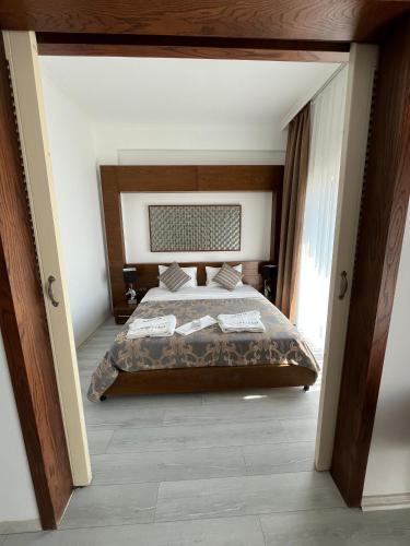 a bedroom with a bed with a wooden headboard at Small Beach Hotel in Bodrum City