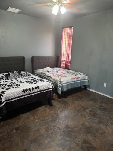 a room with two beds and a chair in it at Master bedroom in Bakersfield