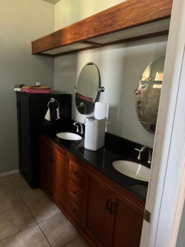 a bathroom with two sinks and a mirror at Master bedroom in Bakersfield