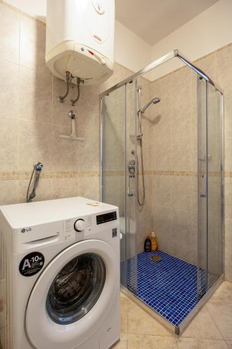 eine Waschmaschine in einem Badezimmer mit Dusche in der Unterkunft Adrian in Rafailovici