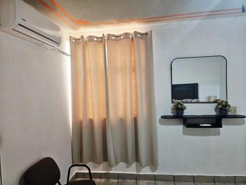 a room with a curtain and a mirror at Flor del desierto in La Paz